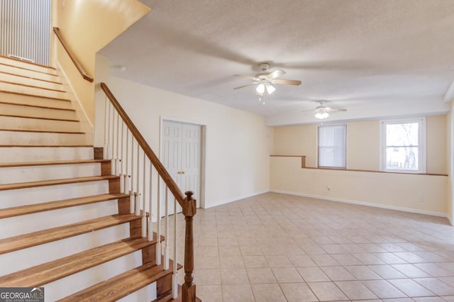 interior space featuring tile patterned flooring, ceiling fan, and a textured ceiling