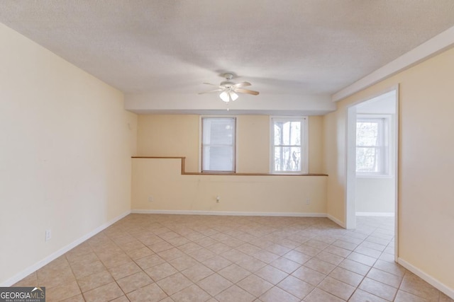 tiled spare room featuring ceiling fan and a textured ceiling