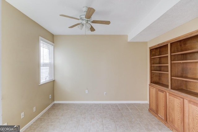 unfurnished room featuring built in features and ceiling fan