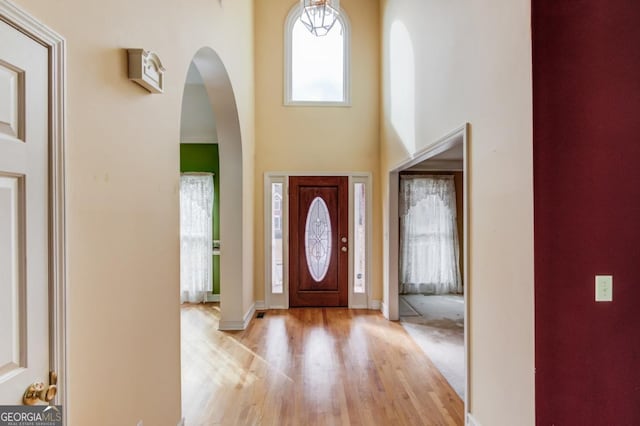 entryway with a towering ceiling and light hardwood / wood-style flooring