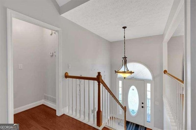 foyer with dark hardwood / wood-style flooring and a textured ceiling