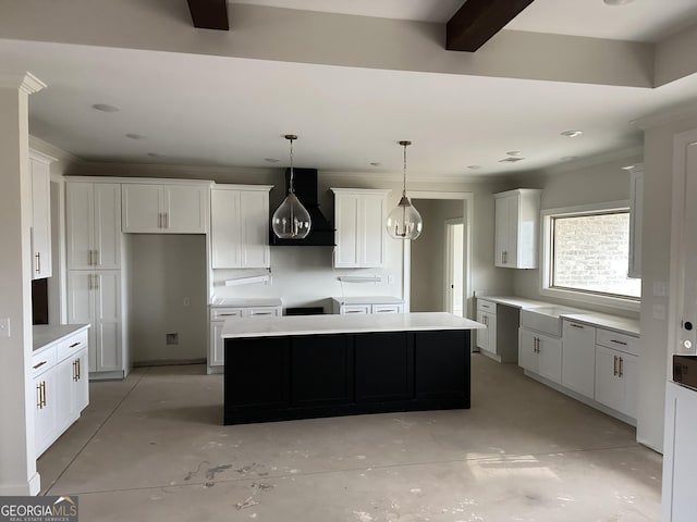 kitchen featuring a kitchen island, beamed ceiling, white cabinetry, hanging light fixtures, and wall chimney range hood