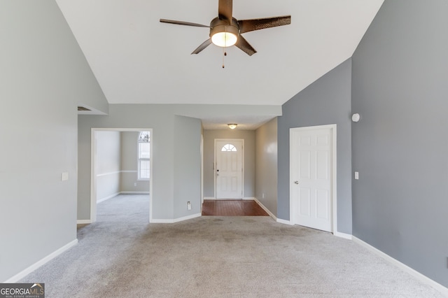 carpeted entrance foyer featuring high vaulted ceiling and ceiling fan