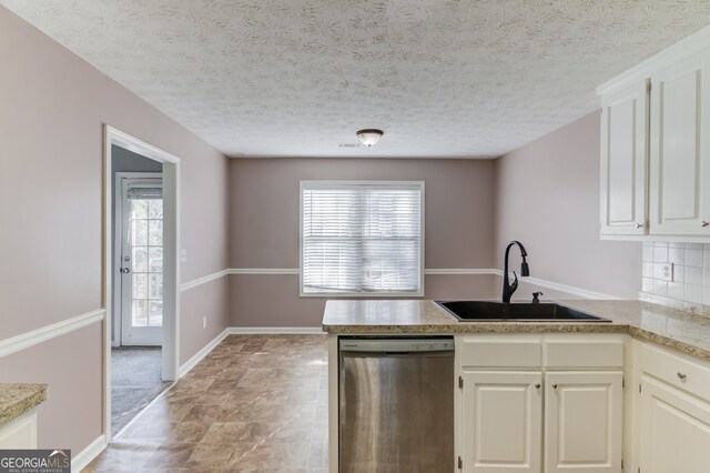 kitchen featuring backsplash, white cabinetry, dishwasher, and sink