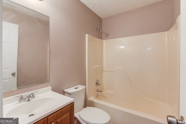 full bathroom featuring vanity, bathtub / shower combination, a textured ceiling, and toilet