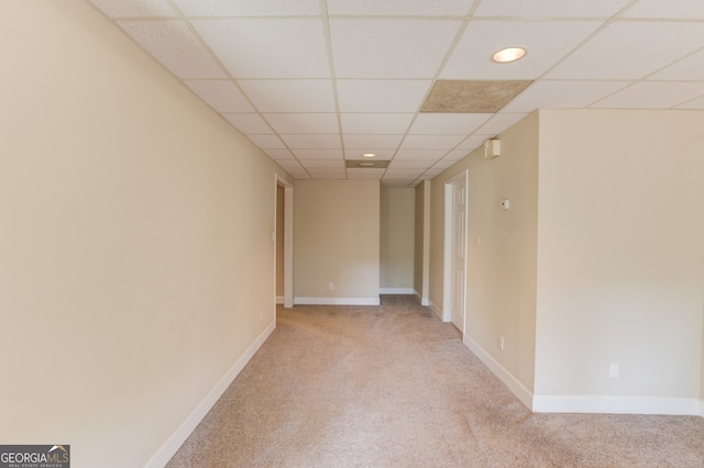 carpeted empty room featuring a drop ceiling