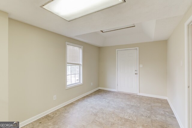 empty room featuring a tray ceiling