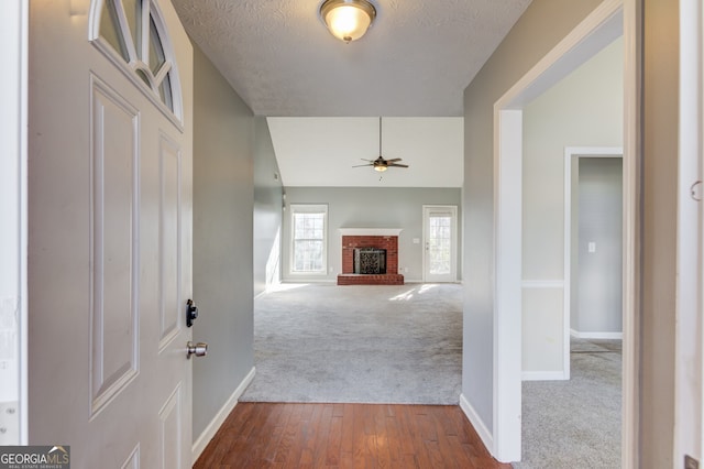 hall featuring carpet floors and a textured ceiling