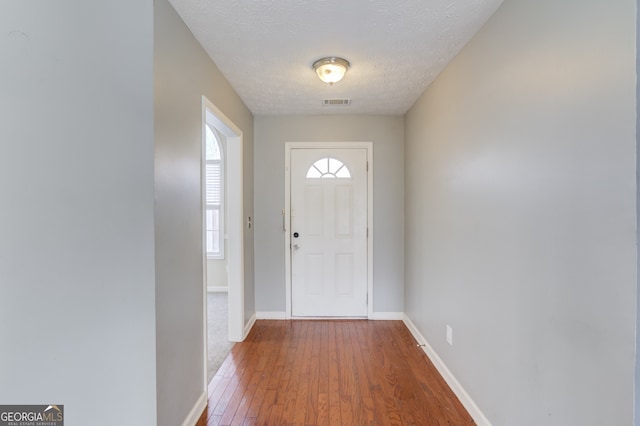 entryway with wood-type flooring and a textured ceiling