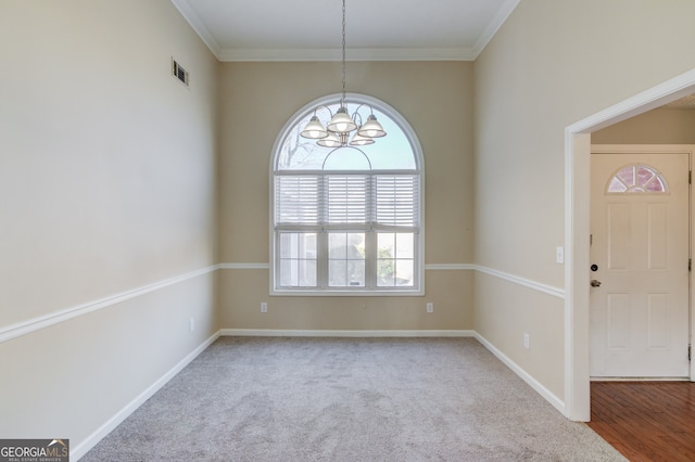 interior space featuring a chandelier, carpet, and ornamental molding