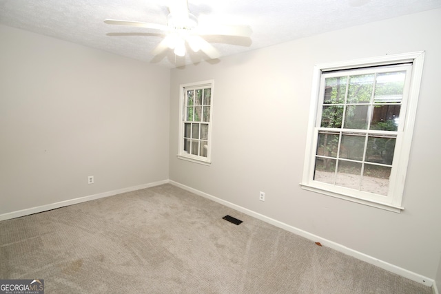 unfurnished room with ceiling fan, carpet floors, and a textured ceiling