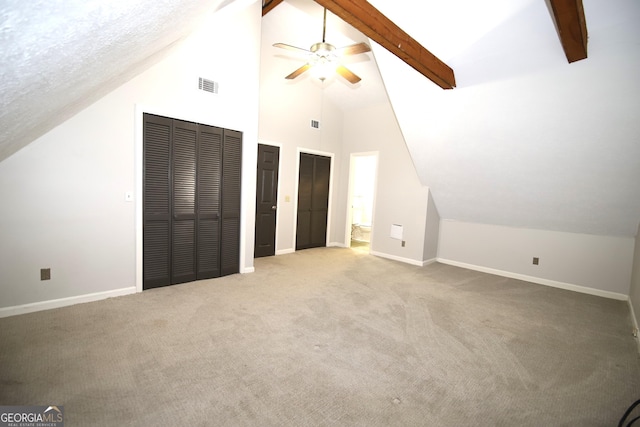 additional living space with beamed ceiling, ceiling fan, light colored carpet, and high vaulted ceiling