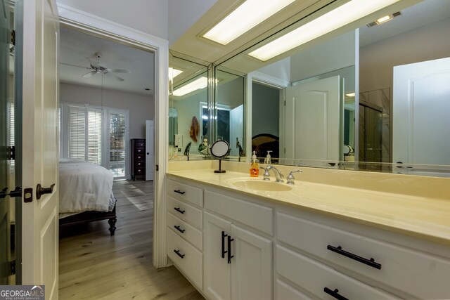 bathroom with ceiling fan, a shower with door, vanity, and hardwood / wood-style flooring