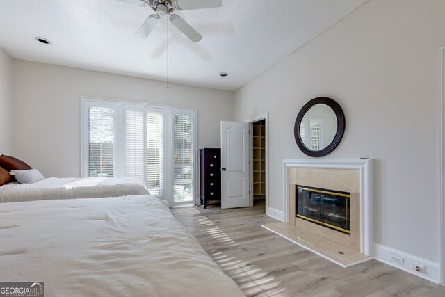 unfurnished bedroom with ceiling fan, light hardwood / wood-style flooring, and a premium fireplace