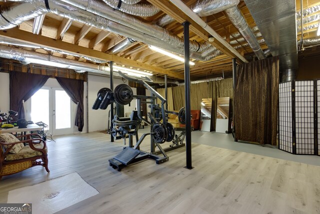 workout room featuring french doors and light hardwood / wood-style floors