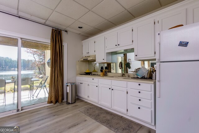 kitchen with a paneled ceiling, sink, light hardwood / wood-style flooring, white fridge, and white cabinetry