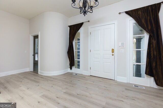 foyer entrance featuring light hardwood / wood-style flooring and a notable chandelier