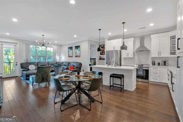 dining space featuring dark wood-style flooring, recessed lighting, visible vents, an inviting chandelier, and ornamental molding