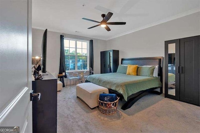 carpeted bedroom featuring ornamental molding and a ceiling fan