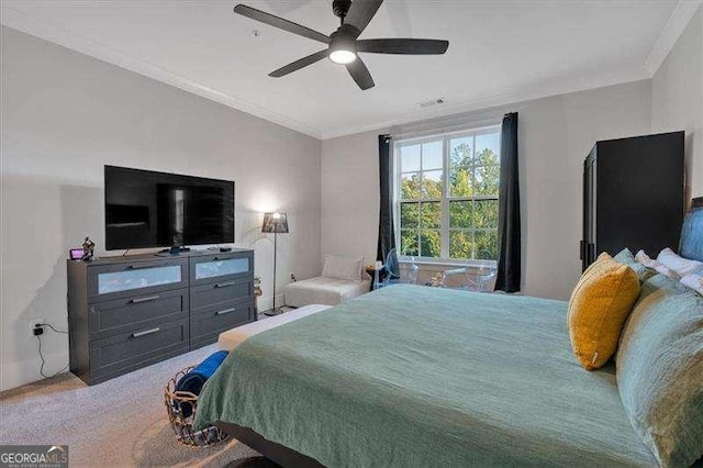 carpeted bedroom with ornamental molding and a ceiling fan