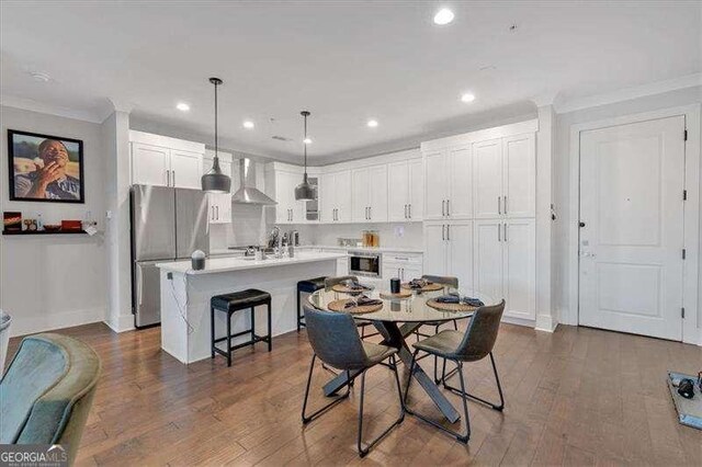 dining area with dark wood-type flooring, crown molding, a notable chandelier, and sink