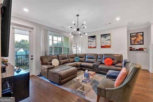 living room featuring an inviting chandelier, crown molding, wood finished floors, and recessed lighting