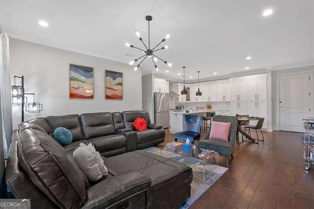 living room with dark wood-type flooring, recessed lighting, and an inviting chandelier