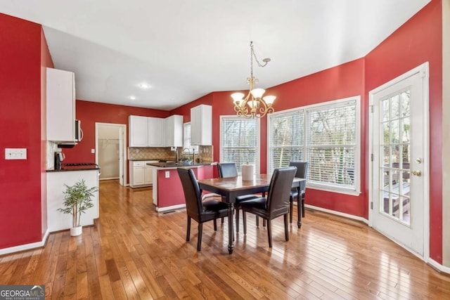 dining room featuring hardwood / wood-style floors, a notable chandelier, and sink