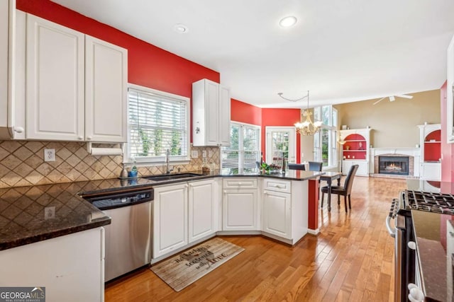 kitchen with white cabinetry, sink, backsplash, pendant lighting, and appliances with stainless steel finishes