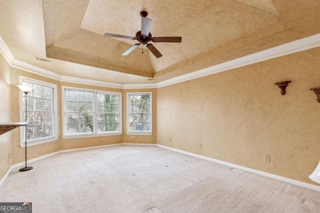 carpeted spare room with a raised ceiling, ceiling fan, and ornamental molding