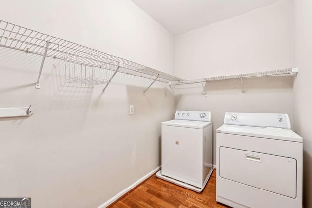 laundry area featuring washing machine and dryer and wood-type flooring