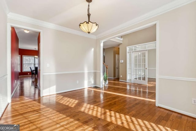 unfurnished room with hardwood / wood-style flooring and ornamental molding