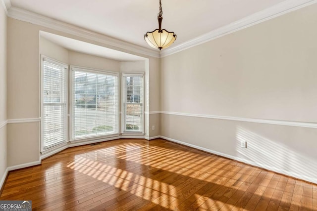 unfurnished room with wood-type flooring and ornamental molding