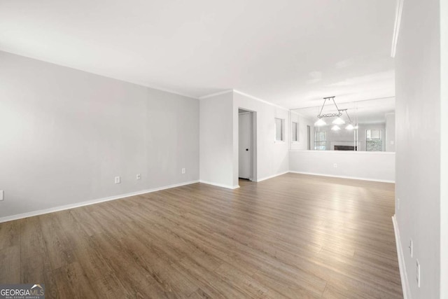 unfurnished living room featuring dark hardwood / wood-style flooring and ornamental molding