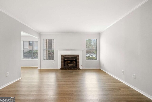 unfurnished living room featuring hardwood / wood-style flooring and ornamental molding