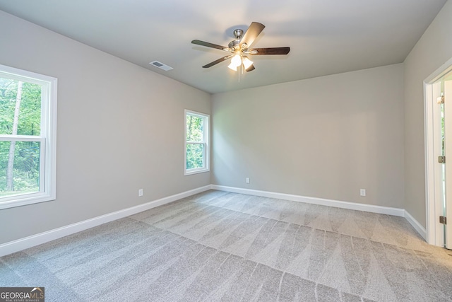 unfurnished room featuring light colored carpet and ceiling fan