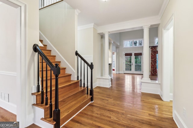 entryway with hardwood / wood-style floors, french doors, and ornamental molding