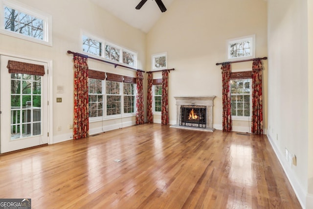 unfurnished living room with ceiling fan, high vaulted ceiling, and a healthy amount of sunlight