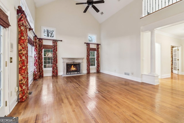 unfurnished living room with ceiling fan, high vaulted ceiling, and light hardwood / wood-style floors