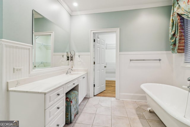 bathroom with a tub, tile patterned flooring, vanity, and ornamental molding