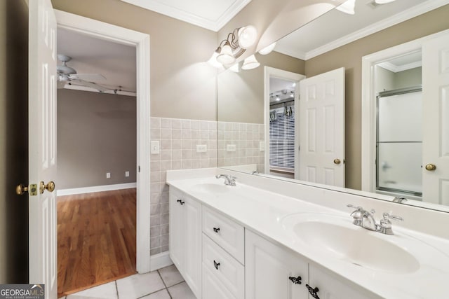 bathroom with tile patterned flooring, ceiling fan, crown molding, and tile walls