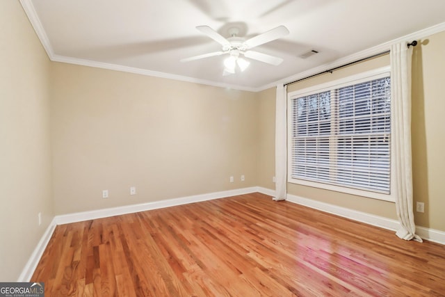 spare room featuring hardwood / wood-style floors, ceiling fan, and crown molding