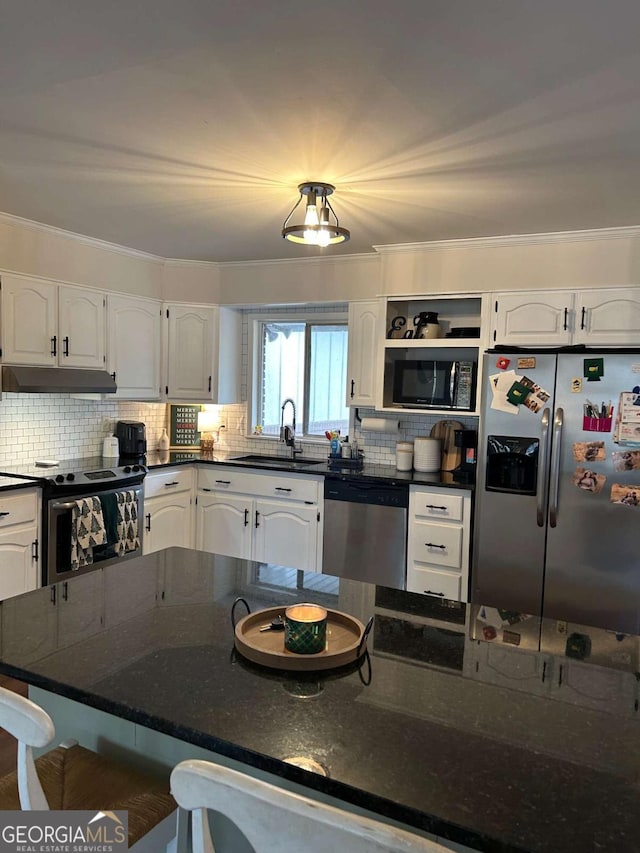 kitchen with appliances with stainless steel finishes, white cabinetry, dark stone counters, and sink