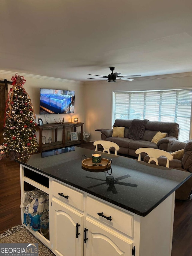 kitchen featuring ceiling fan, crown molding, white cabinets, and dark wood-type flooring