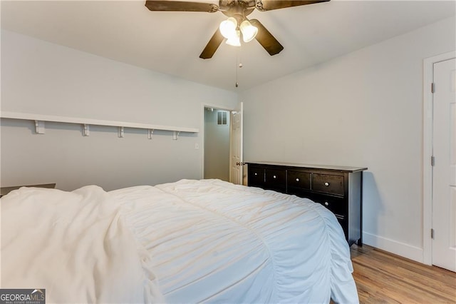 bedroom with ceiling fan, light hardwood / wood-style floors, and vaulted ceiling