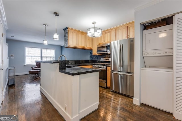 kitchen featuring stacked washer and dryer, light brown cabinetry, stainless steel appliances, and pendant lighting