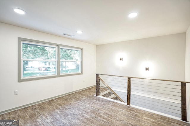 unfurnished room with hardwood / wood-style flooring