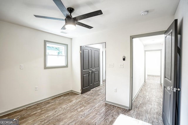 unfurnished room with ceiling fan and hardwood / wood-style flooring