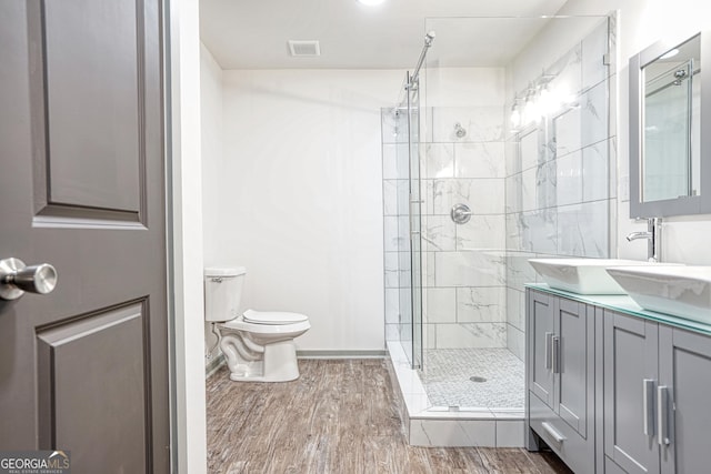 bathroom featuring toilet, a shower with door, hardwood / wood-style flooring, and vanity