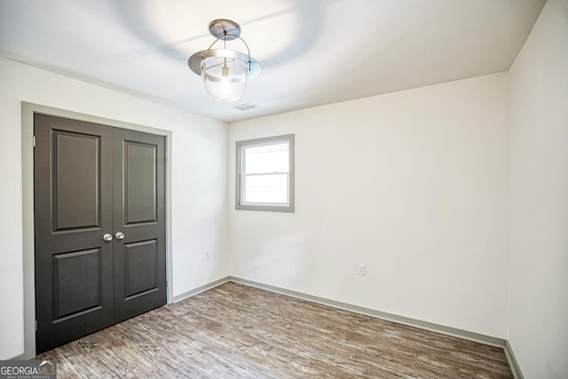 unfurnished bedroom featuring a closet and hardwood / wood-style flooring